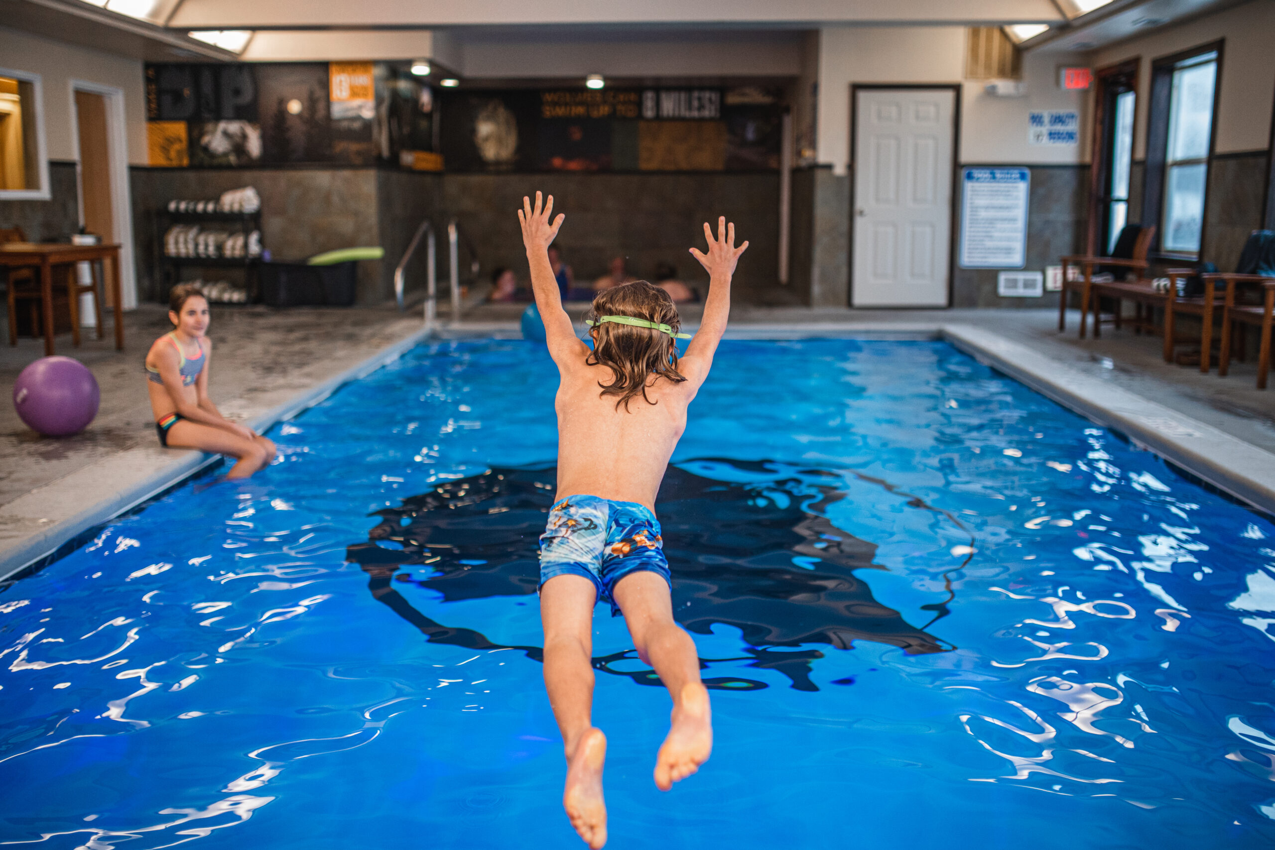 Two kids swimming in the indoor pool at Gray Wolf Inn & Suites