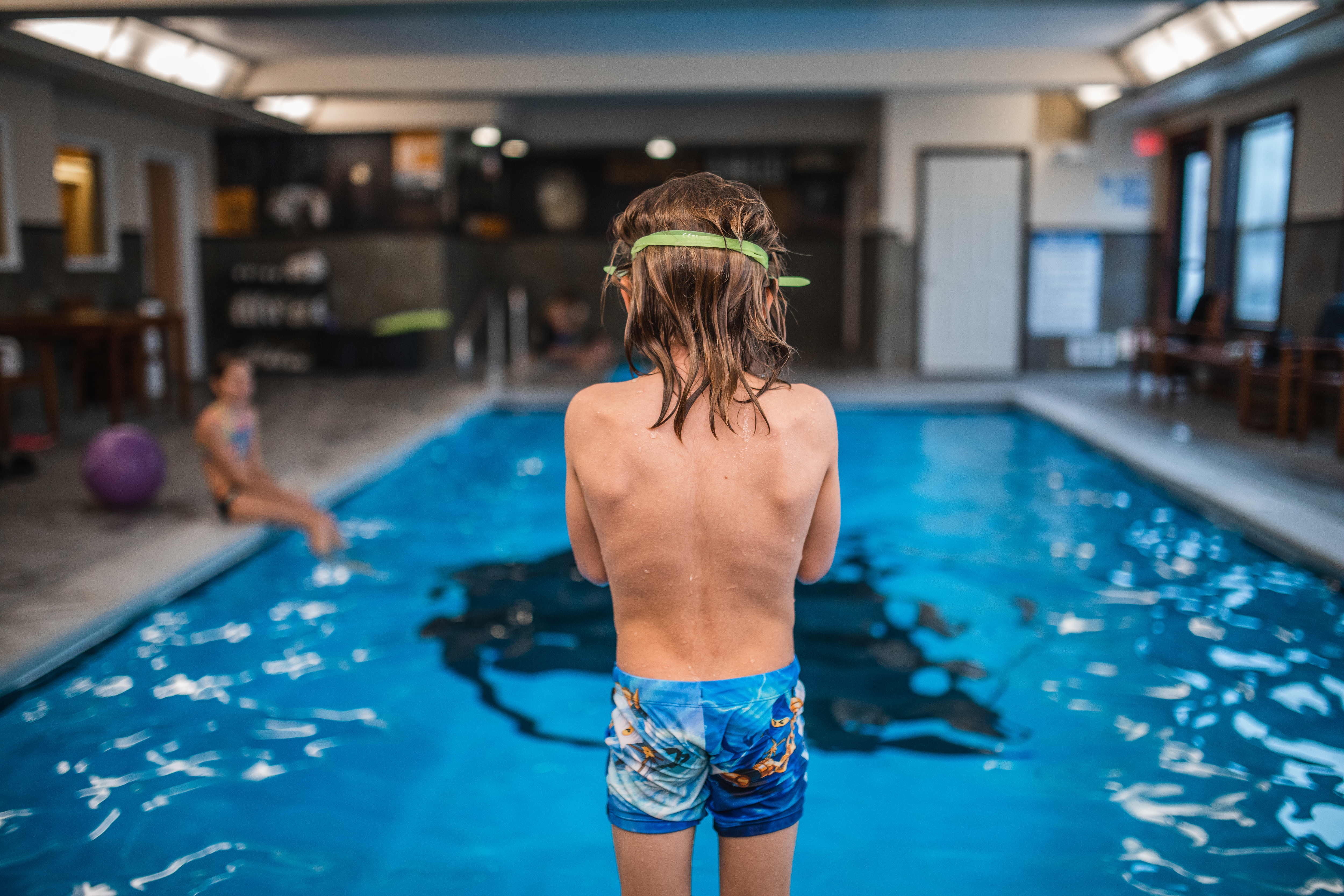 Two kids swimming at the indoor pool at Gray Wolf Inn & Suites